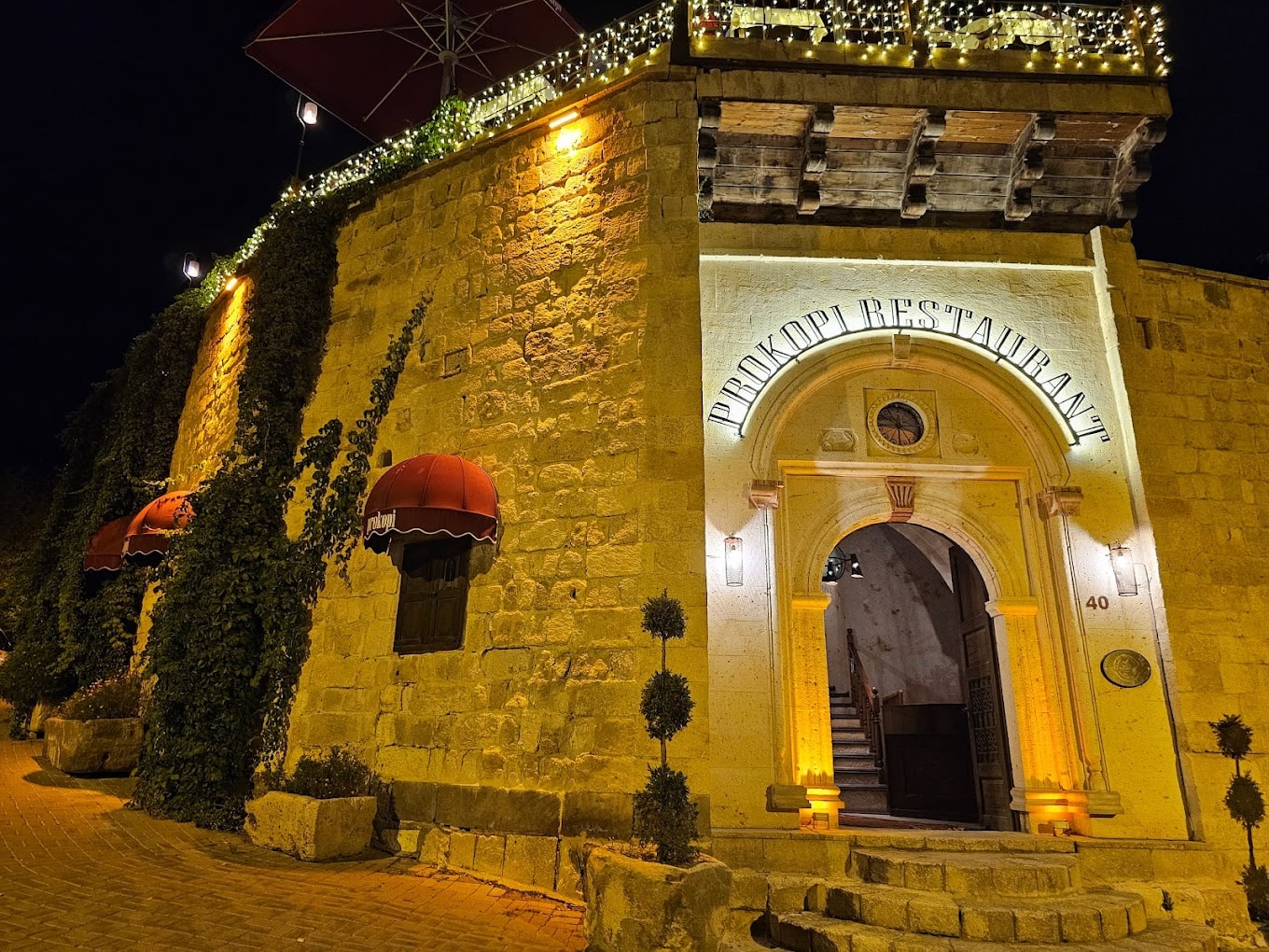 Prokopi Restaurant taş cephesi ve kırmızı tenteli girişi